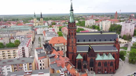 Aerial-View-Of-Legnica-Cathedral-With-Saint-John-the-Baptist-Church-In-The-Distance-In-Poland