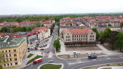 Vista-Aérea-De-Los-Automóviles-Circulando-Por-La-Calle-Frente-Al-Complejo-De-Escuelas-Económicas-En-Legnica,-Polonia.