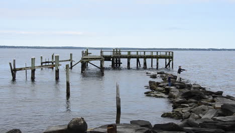 Rocky-Point-Park-Hombre-E-Hijo-Pescando-En-Un-Muelle-Destruido-En-Una-Costa-Rocosa-En-Un-Día-Tranquilo-Del-Océano