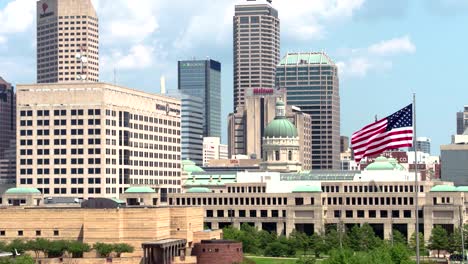 Aerial-View-of-Downtown-Indianapolis,-Indiana-Drone-Shot-in-4K-with-US-Flag-Waving-in-Marion-County