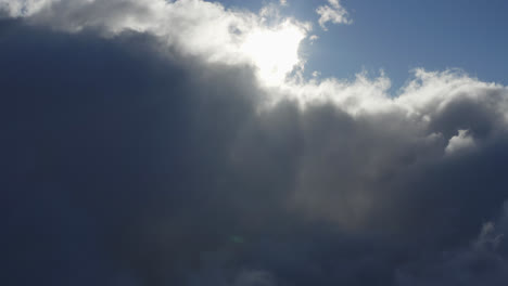 Dicke-Wolkenfront-Rollt-Langsam-über-Den-Himmel,-Während-Sonnenstrahlen-In-Angenehmen-Lichtschein-Eindringen