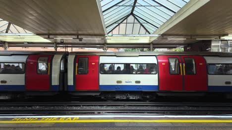 Tren-De-La-Línea-Jubileo-Con-Pasajeros-Que-Salen-De-La-Estación-De-Metro-Finchley-Road-En-Londres,-Reino-Unido