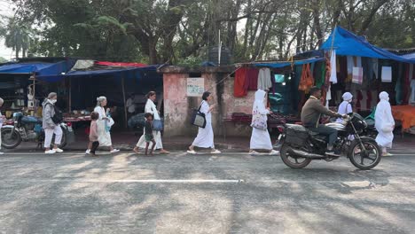 Side-view-of-Buddhist-pilgrim-walking-in-Gaya-market-in-Bihar,-India