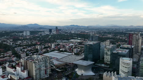 Vista-Aérea-Hacia-Atrás-Sobre-Edificios-únicos-En-Polanco,-Noche-En-La-Ciudad-De-México