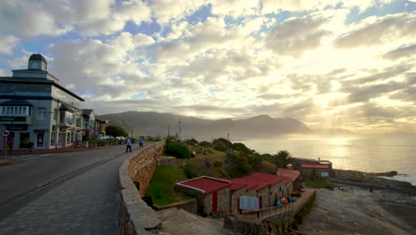 Blick-Von-Der-Küste-Von-Hermanus-Auf-Die-Goldenen-Strahlen-Des-Sonnenaufgangs,-Die-Durch-Die-Wolken-Brechen