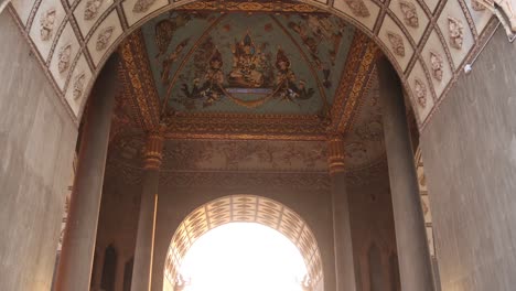 Looking-into-the-archway-with-beautiful-paintings-and-carvings-inside-Patuxai-Victory-Monument-in-the-center-of-Vientiane,-Laos