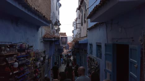 Un-Grupo-De-Turistas-Está-Haciendo-Turismo-En-El-Casco-Antiguo-De-Chefchaouen,-Marruecos,-En-Las-Estrechas-Calles-Rodeadas-De-Casas-Azules-Y-Artesanías.