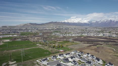 Flying-over-scenic-Lehi-city-valley-with-snowy-mountain-background,-Utah