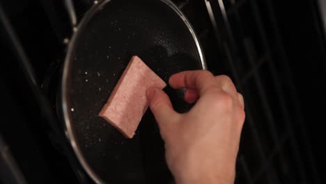 Vertical-static-shot-of-person-put-processed-canned-spam-meat-on-frying-pan
