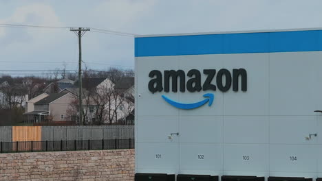 Aerial-drone-establishing-shot-of-Amazon-Logo-on-distribution-center-warehouse