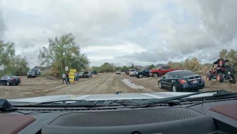 POV---Driving-through-the-overflow-parking-for-Sports,-Vacation-and-RV-Show-with-a-million-attendees,-on-rainy-day