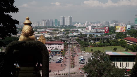 Scenic-View-of-Kuala-Lumpur-Skyline-and-the-Murugan-Statue-from-the-Top-of-the-Stairs-of-the-Batu-Caves