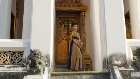 Thai-young-woman-posing-at-golden-entrance-of-Grand-Palace-in-Thailand