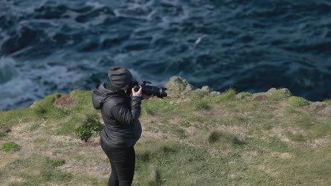 Static-shot-of-a-wildlife-photographer-capturing-puffins-on-Lunga-Island