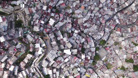 Winding-streets-of-Medellin’s-Comuna-13-weave-a-dense-urban-fabric,-colombia---aerial-top-view