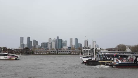 Capturando-La-Vista-Panorámica-Del-Muelle-De-Greenwich-Con-El-Telón-De-Fondo-Del-Icónico-Horizonte-De-Canary-Wharf,-Encarnando-El-Concepto-De-Yuxtaposición-Entre-El-Encanto-Histórico-Y-La-Grandeza-Moderna.