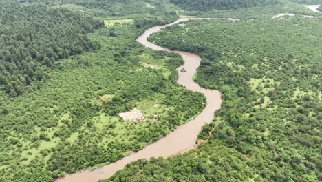 A-drone-shot-of-a-river-winding-through-a-Kakamega-Forest-in-Western-Kenya