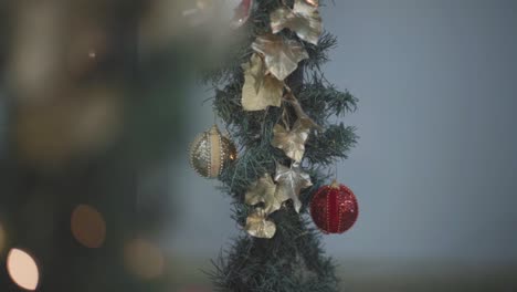 Christmas-Light-Decorations-Sparkling-on-Stairs,-Garland-Ornaments-with-Bokeh-Close-Up-Natural-Light-Vertical-Pan