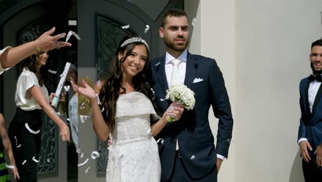 Diverse-couple-enjoys-joyful-wedding-moment,-surrounded-by-friends-and-confetti