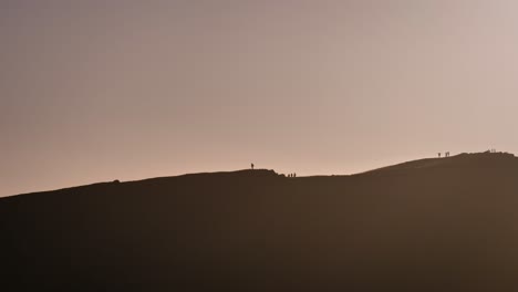 Handheld-view-of-people-on-Arthur's-Seat-from-Calton-Hill-at-sunrise,-Edinburgh,-Scotland