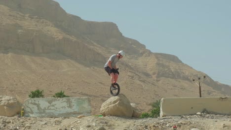 Man-unicycle-on-rough-mountain-terrain