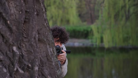 Paparazzi-hide-behind-tree-and-do-investigation-with-digital-camera-equipment