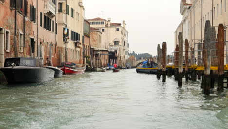 Typical-Venetian-scene,-boats-sailing-and-anchored-in-canal