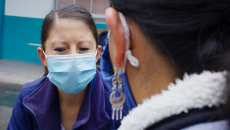 Detail-shot-of-women-with-masks-talking