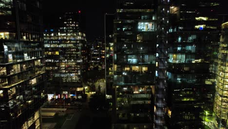 Luftaufnahme-Eines-Dollys-Seitwärts-Entlang-Moderner-Gebäude-In-Nueva-Las-Condes-Mit-Eingeschalteter-Beleuchtung-In-Der-Nacht,-Santiago,-Chile