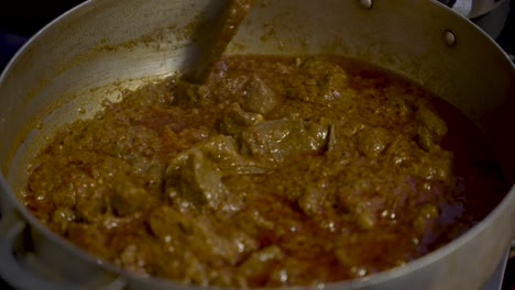 Cucharón-De-Madera-Revolviendo-Salsa-De-Curry-Chisporroteante-Con-Carne-Picada-Con-Vapor-En-Ascenso