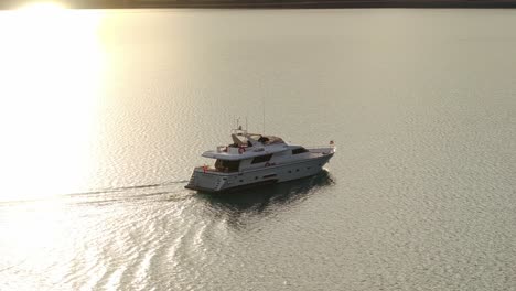 Sun-ray-beam-shines-across-tour-boat-yacht-in-middle-of-lake