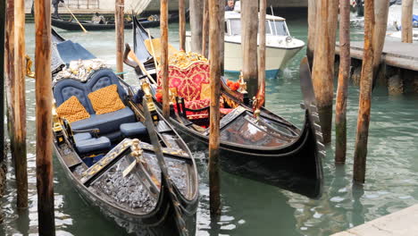 Close-up-high-angle-shot-of-two-gondolas-anchored-at-pier-in-Venice,-Italy