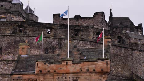 Totale-Aufnahme-Von-Flaggen-Vor-Dem-Eingang-Des-Edinburgh-Castle-Von-Der-Esplanade-Aus-Gesehen,-Schottland