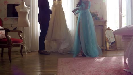 Slow-motion-shot-of-a-man-holding-the-brides-wedding-dress-showing-it-off