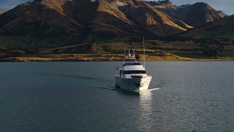 Paralaje-De-órbita-Aérea-Frontal-Alrededor-Del-Recorrido-En-Yate-En-La-Base-De-Las-Montañas-Sobre-El-Lago-Wakatipu