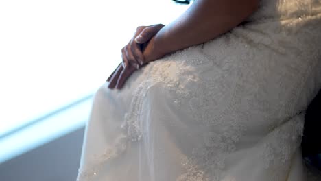Fangen-Sie-Die-Eleganz-Einer-Braut-Ein,-Die-Im-Sitzen-Anmutig-Ihr-Hochzeitskleid-Hebt