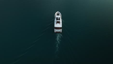 Drone-De-Arriba-Hacia-Abajo-Con-Grúa-Panorámica-Disparada-Sobre-Un-Recorrido-En-Yate-En-El-Lago