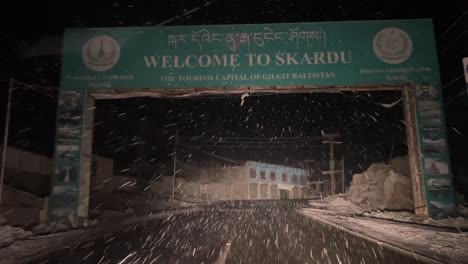 Point-of-view-shot-of-a-car-driving-on-the-streets-of-Skardy-City-during-snowfall-at-night,-Pakistan