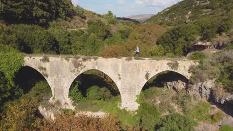 Un-Excursionista-Solitario-Aventurero-Cruza-Un-Antiguo-Puente-Acueducto-En-Creta,-Grecia