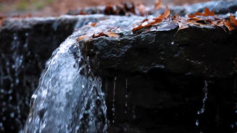 Water-flowing-over-rocks-forming-a-waterfall-in-autumn