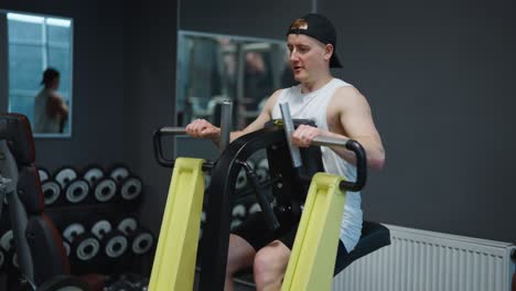 Kaukasischer-Männlicher-Athlet-Trainiert-Die-Rückenmuskulatur-Mit-Einer-Hebelwirkung-Auf-Einer-Niedrigen-Rudermaschine