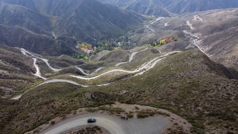 Winding-dirt-road-descends-to-autumn-valley-in-dramatic-switchbacks