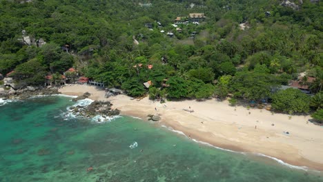 Incredible-aerial-view-over-sandy-beach-on-tropical-island-with-jungle
