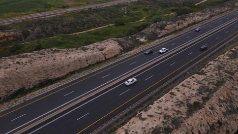 Aerial-view-of-a-highway-with-vehicles-by-rocky-terrain