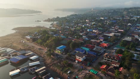 A-picturesque-village-in-Songklaburi,-Thailand,-nestled-along-the-banks-of-the-Khwae-Noi-River,-exuding-charm-and-tranquility