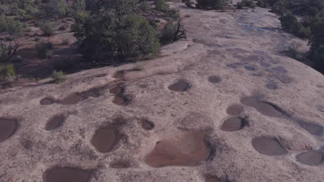 Escena-Aérea-Sobre-Charcos-De-Agua-De-Lluvia-En-Slickrock-En-El-Desierto-De-Moab---Utah