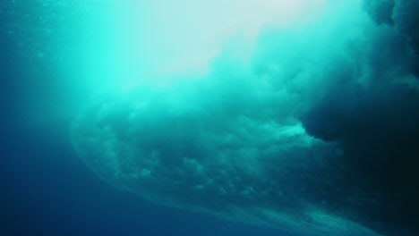 Ocean-wave-picks-up-into-vortex-crashing-and-spinning-in-deep-blue-water-above-reef