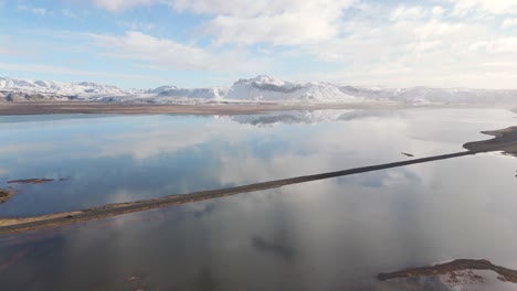 Reflected-clouds,-Icelandic-water-landscape-volcanic-snowy-mountains-drone-shot
