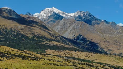 Lebendige-Grüne-üppige-Landschaft-Der-Glenorchy-Mountains-Mit-Wolkenschatten-Und-Schnee