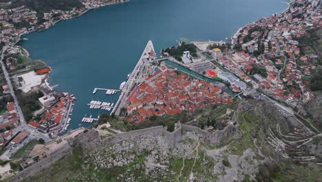 4K-drone-footage-captures-Kotor-Fortress-and-UNESCO-listed-Old-Town-and-port-in-the-Bay-of-Kotor,-Montenegro